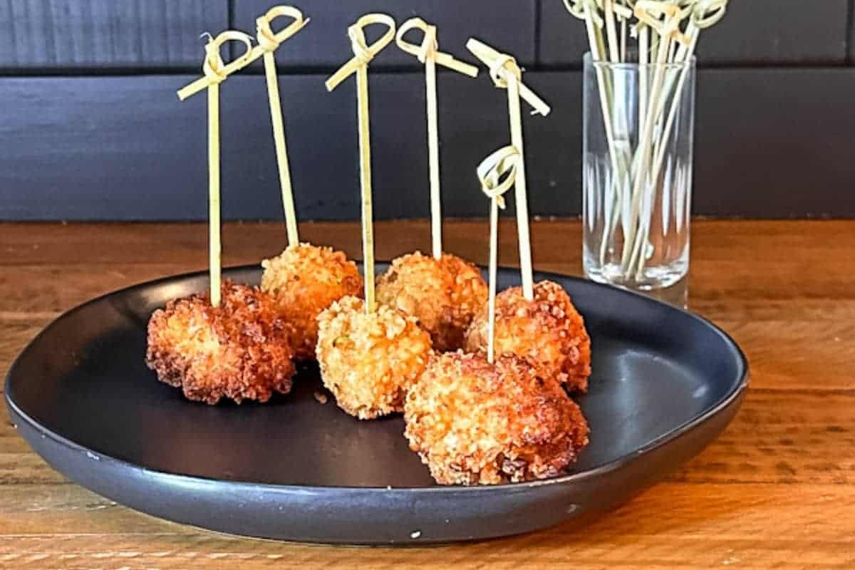 Shrimp Balls on black plate with food picks