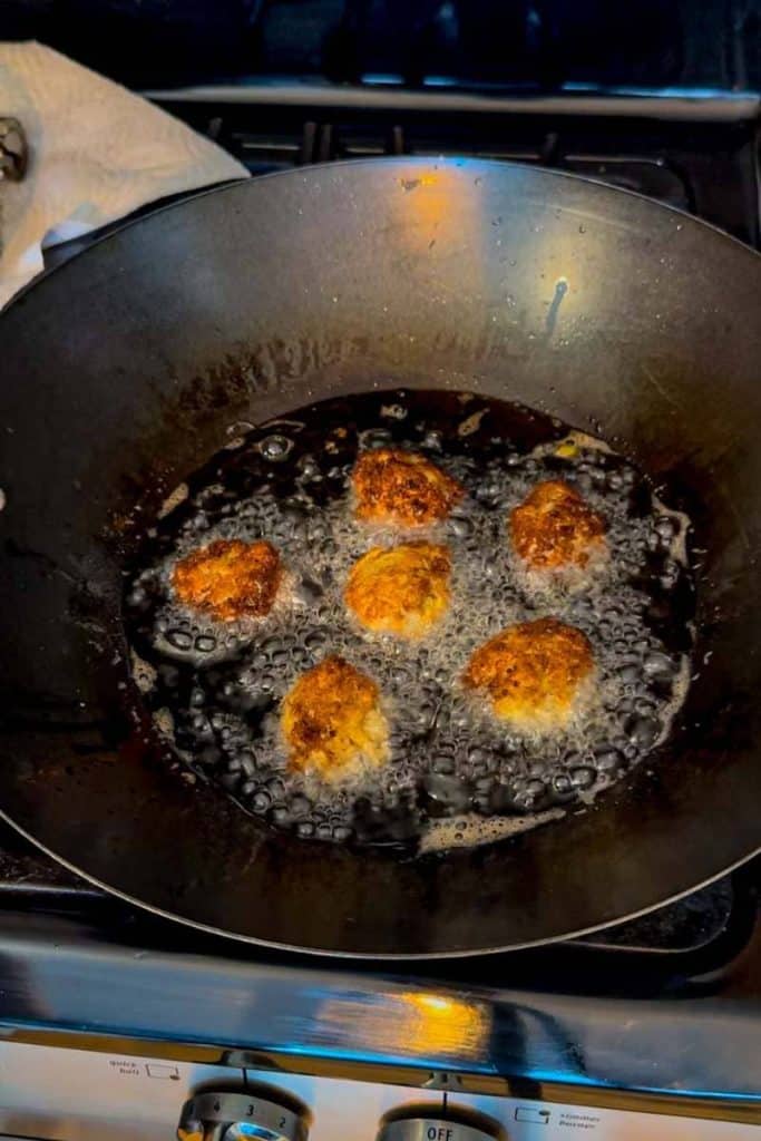 shrimp balls in wok frying in oil