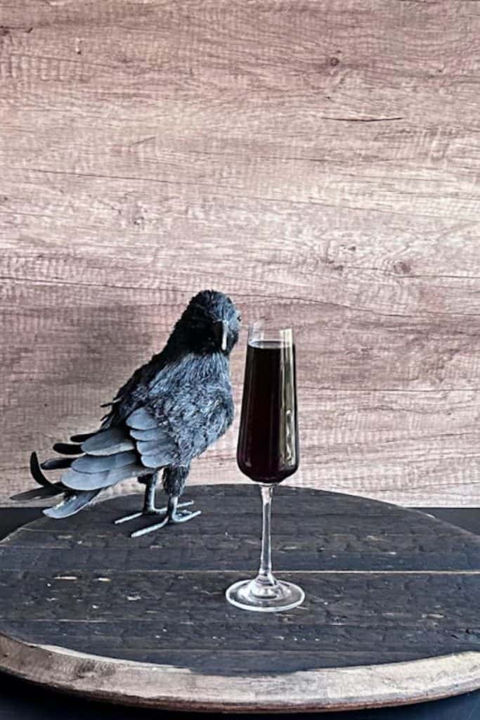 black raven black vodka drink in champagne glass next to a raven