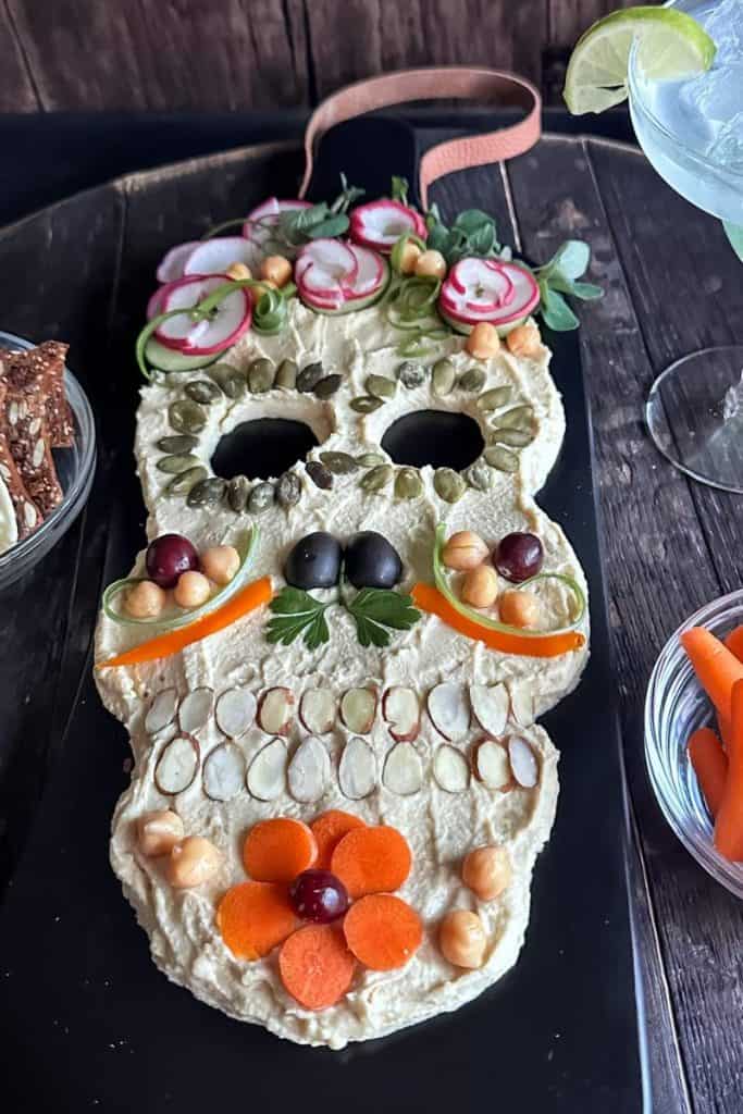 day of the dead hummus tray with radishes, sliced almonds, carrots etc